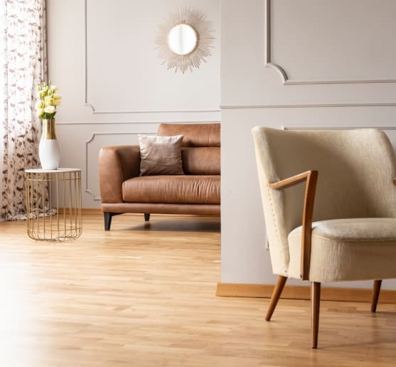 Cozy living room with a brown leather sofa and wooden chair.