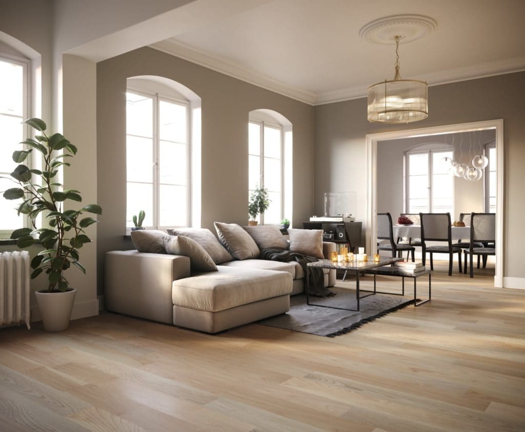 A modern living room with a beige sectional sofa and large windows.