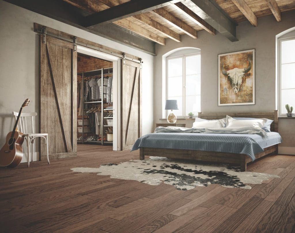 Cozy bedroom with rustic wooden beams and sliding barn doors.