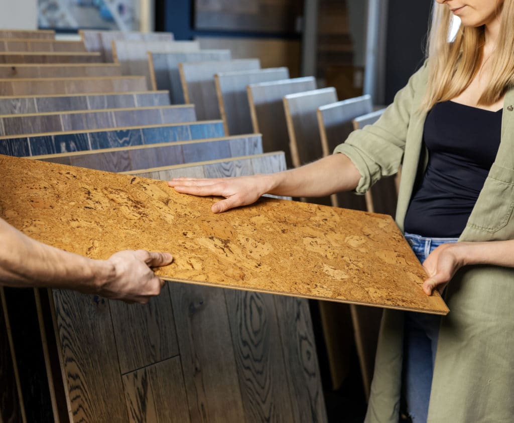 Two people examining a wooden flooring sample.